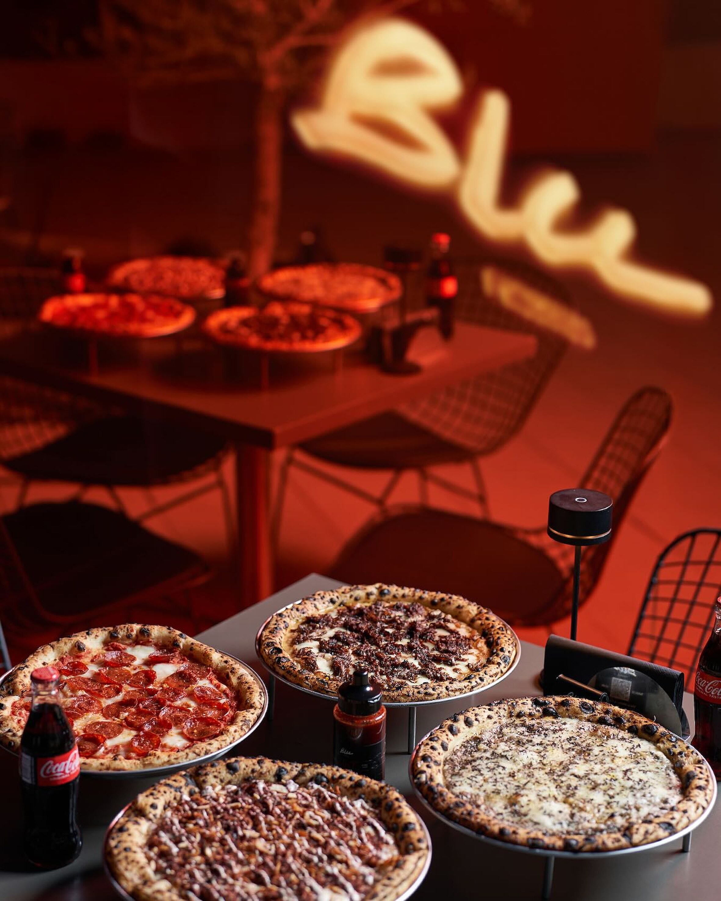 Blu dining room in red light beneath the neon script