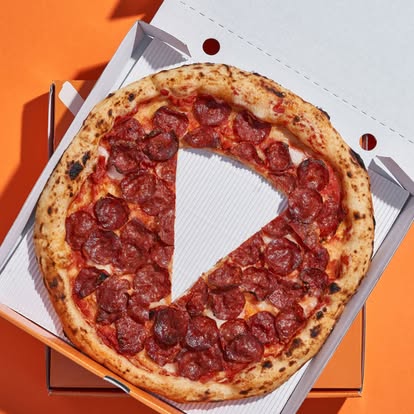 Spicy pepperoni with a slice cut, in the box